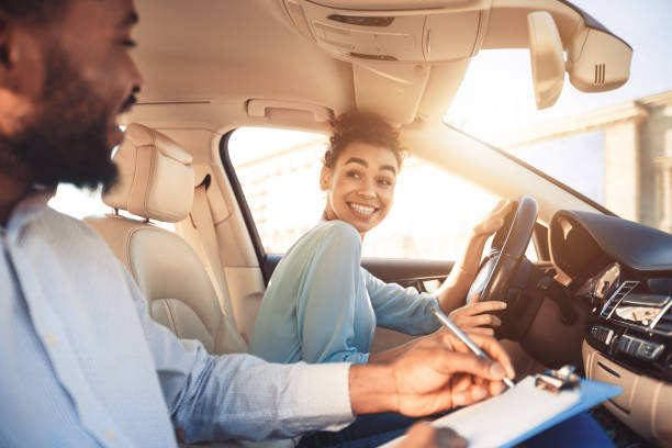 mulher feliz no carro da examinação, sorrindo ao instrutor masculino - aprender a conduzir - fotografias e filmes do acervo