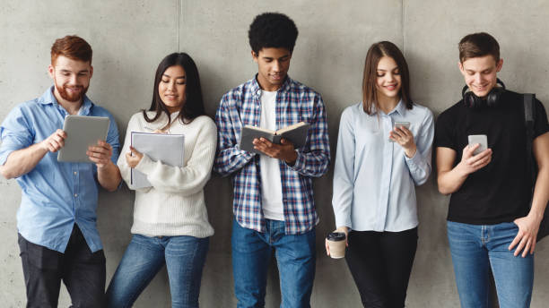istock Diverse students with books standing near grey wall 1168372423