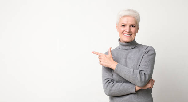 istock Happy aged woman pointing aside on copy space, recommending something 1168372529