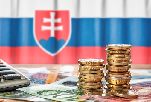 Billetes y monedas en euros frente a la bandera nacional de Eslovaquia photo