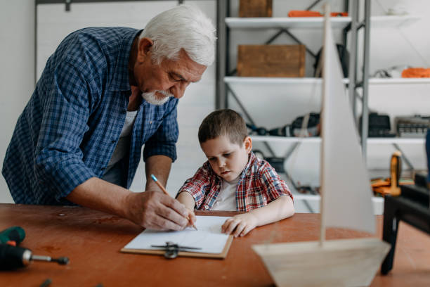 istock Grandson helping grandfather crafting 1168372766