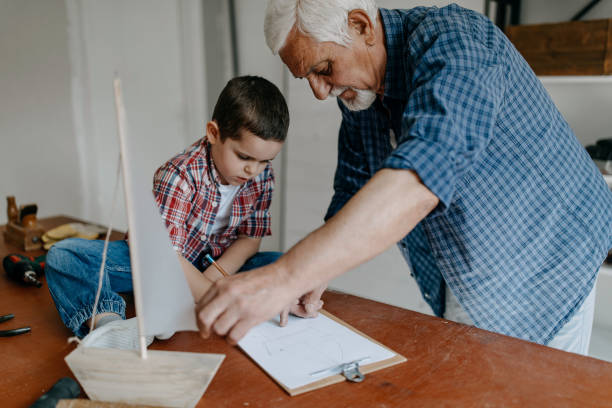 istock Grandson helping grandfather crafting 1168372926