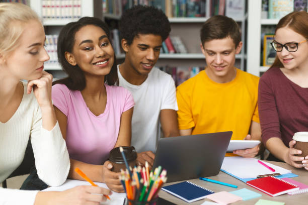 istock Young international team of students studying at library 1168372990