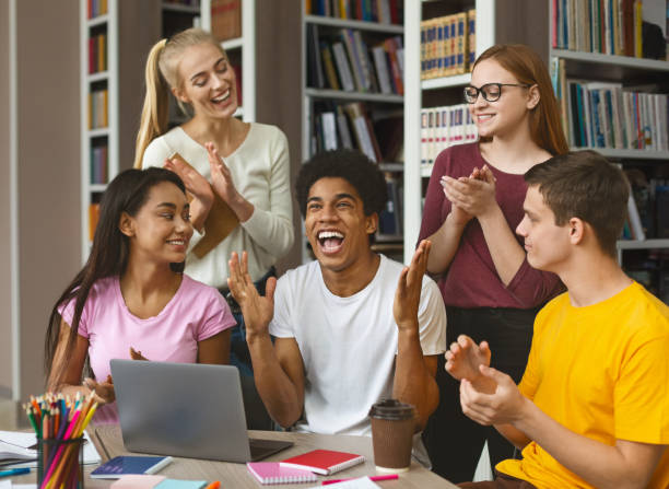 istock School friends congratulating euphoric african american guy 1168373035