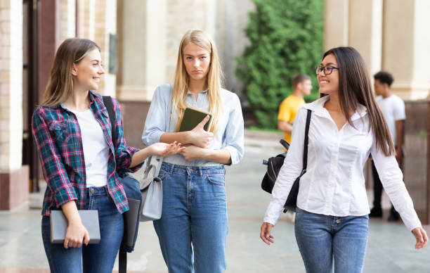 istock Students avoid talking to friend, walking in college campus 1168373440