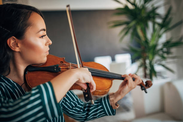 istock Young woman violinist practicing at home 1168374798