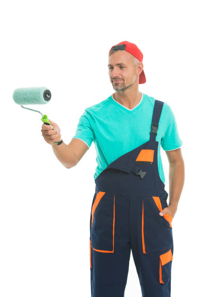 istock Paint and renovate. Decorator painting wall. Man in cap hold paint roller white background. Worker painter decorator concept. Decorator creative work. Professional occupation. Education for decorator 1168378900