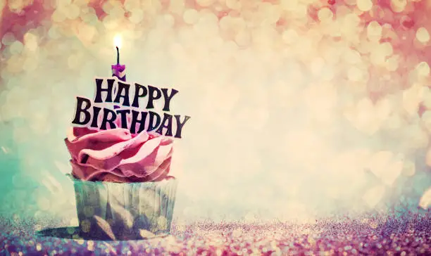 Photo of Happy birthday cupcake on glitter colorful background