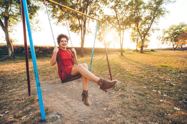 istock Young woman on a swing in a park 1168379890