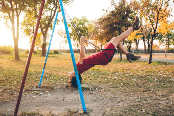 istock Young woman on a swing in a park 1168379899