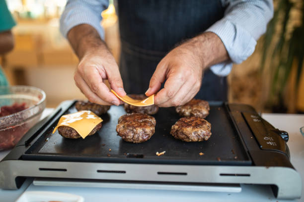 istock Putting cheese on burgers 1168380949