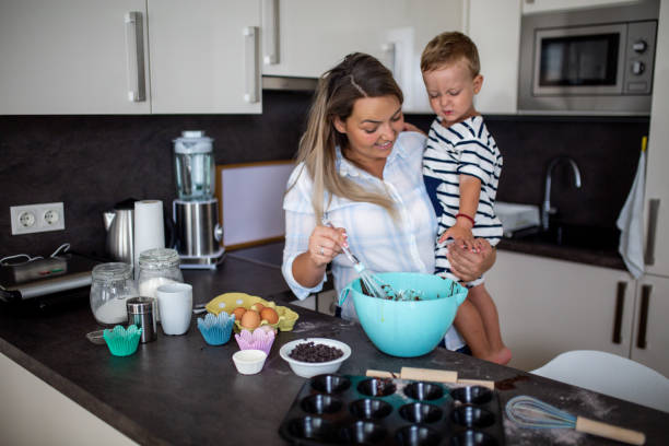 istock Young pretty mother bakes biscuits with her young son 1168381180