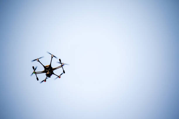 istock black drone is flying in a blue sky 1168381295