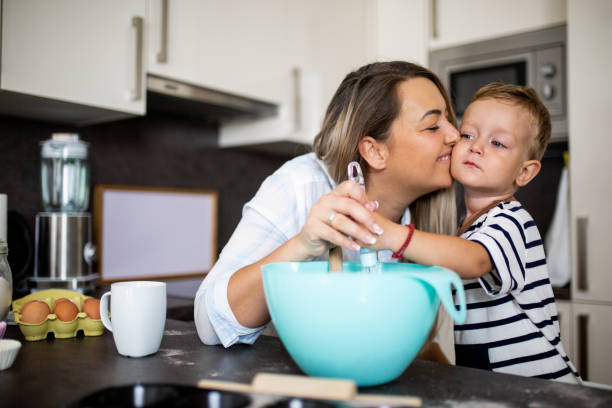 istock Young pretty mother bakes biscuits with her young son 1168381304