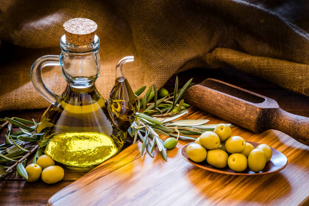 istock Olive oil bottle with olive branch on a olive wooden cutting board with copy space 1168382099