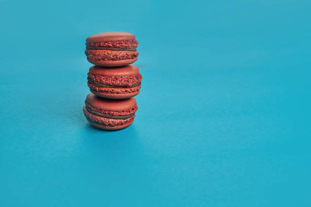 istock Colored macaron or macaroon, sweet meringue-based confection on blue background. Close-up, copy space 1168382318