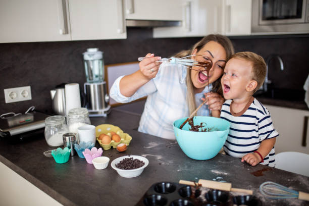 istock Young pretty mother bakes biscuits with her young son 1168383338