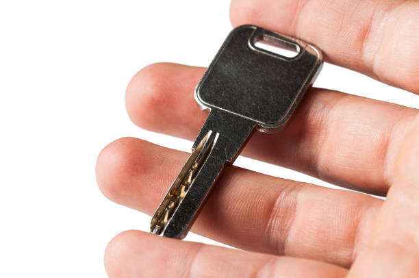 istock Metal silver key in hand isolated on white background 1168385406