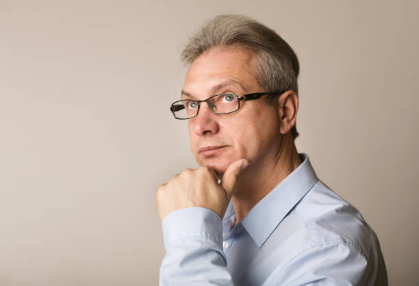 istock Serious mature businessman thinking, holding hand on chin 1168386128