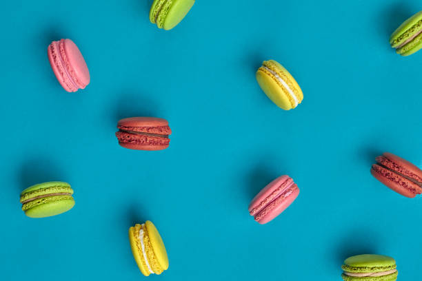 istock Colored macaron or macaroon, sweet meringue-based confection on blue background. Close-up, copy space 1168386436