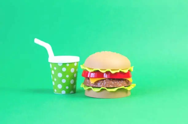 Photo of Toy fastfood food and drink on an green background.