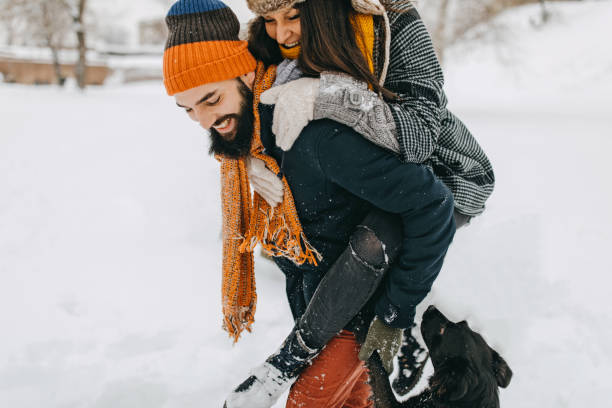 istock Happy young couple having fun in snow 1168401863