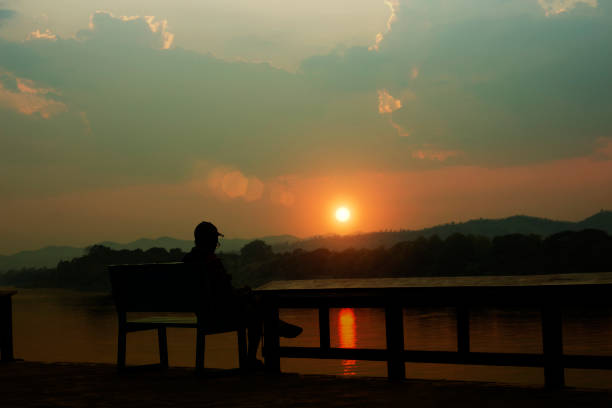 istock The old man sits at a bench near the river 1168403123