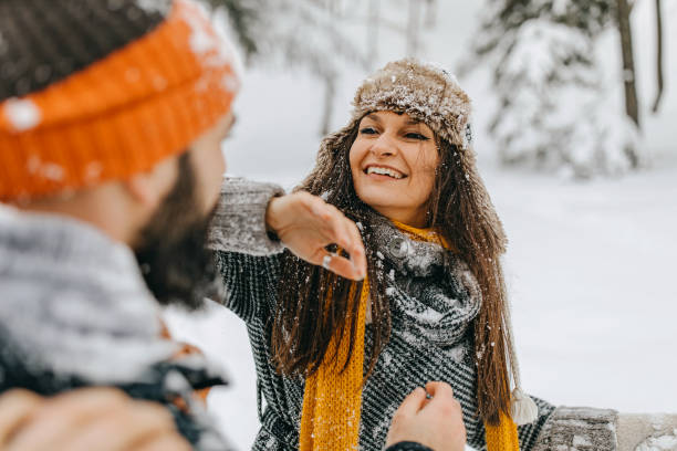 istock Happy young couple having fun in snow 1168404435