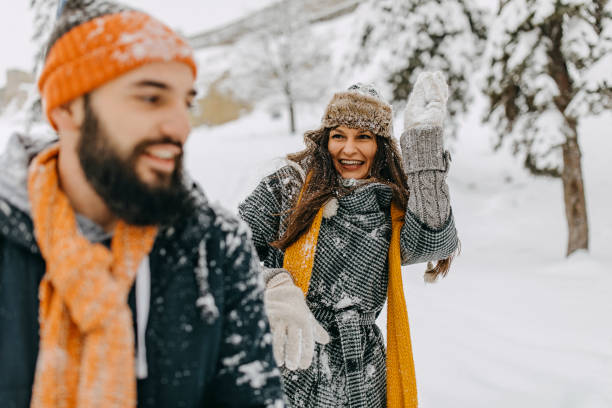 istock Happy young couple having fun in snow 1168404571