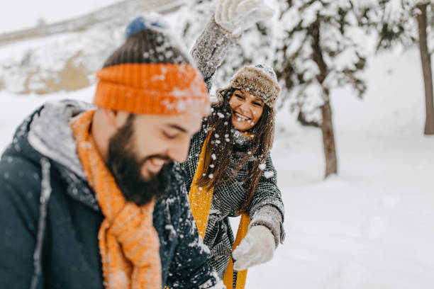istock Happy young couple having fun in snow 1168404826