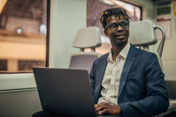 istock Businessman using laptop in subway train 1168406075