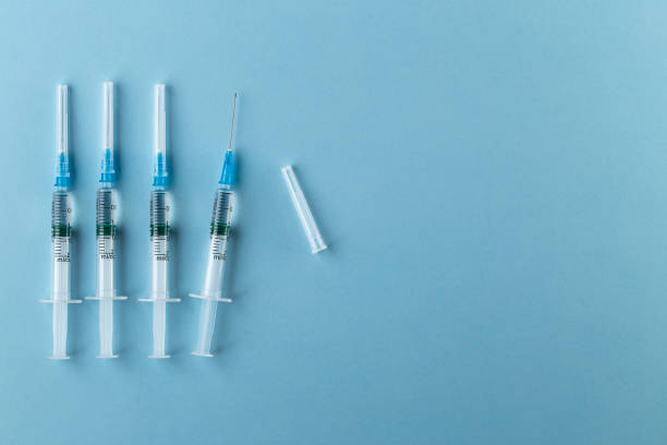 syringe sur le fond bleu - surgical needle photos photos et images de collection