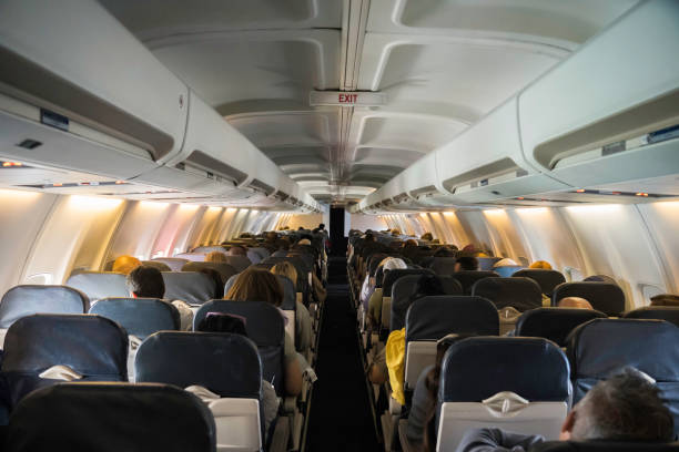 Commercial aircraft cabin with rows of seats down the aisle stock photo