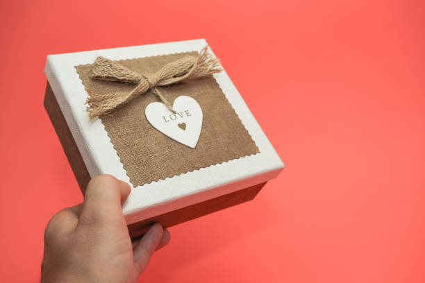 istock Hand holding Beautiful vintage gift box on a red background. 1168412198