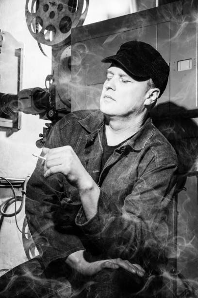 映画の部屋で喫煙疲れた投影家の白黒写真。全てが煙の中にある。 - projectionist ストックフォトと画像