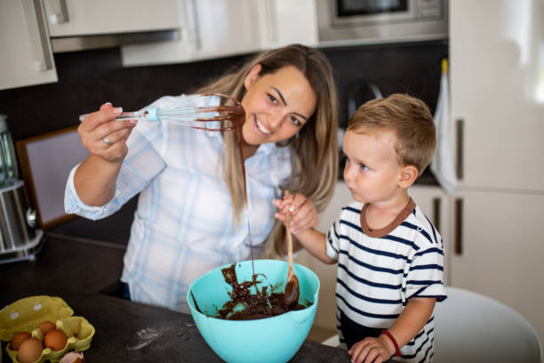 istock Young pretty mother bakes biscuits with her young son 1168413525
