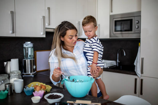 istock Young pretty mother bakes biscuits with her young son 1168413613