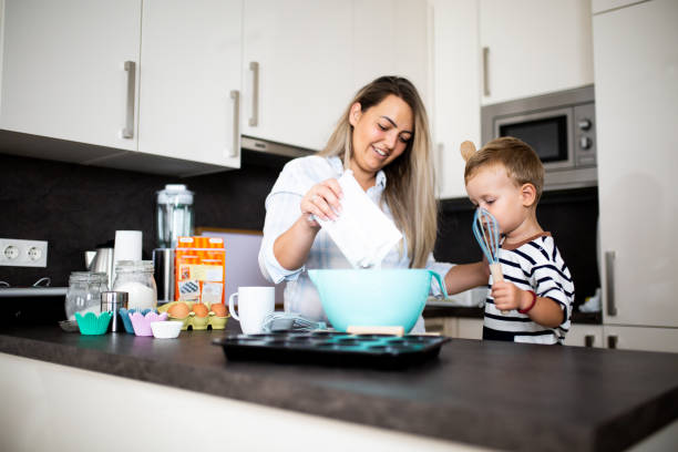 istock Young pretty mother bakes biscuits with her young son 1168413873