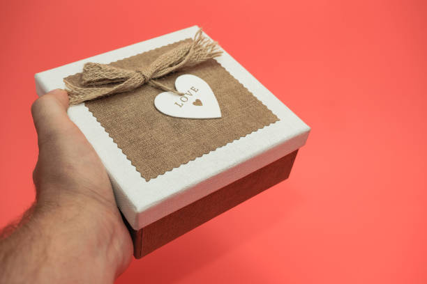 istock Hand holding Beautiful vintage gift box on a red background. 1168414753