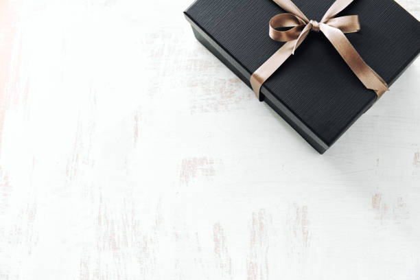istock Gift wrapped in dark paper on white background 1168415073
