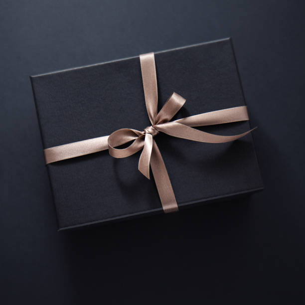 istock Gift wrapped in dark paper on dark background 1168415171