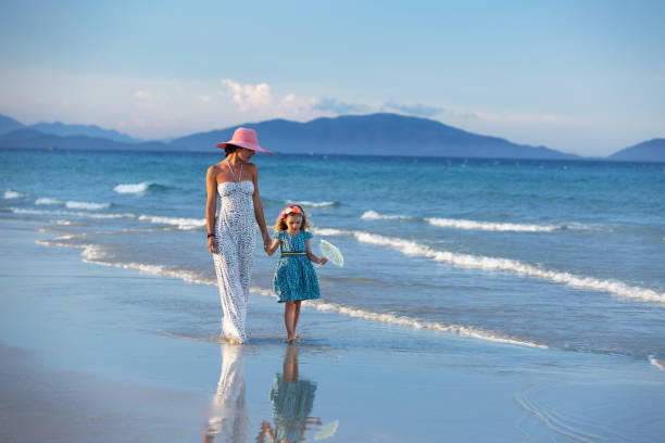 istock Mother and daughter walking along seaside at afternoon 1168416548