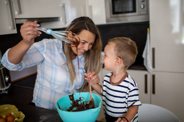 istock Young pretty mother bakes biscuits with her young son 1168417151