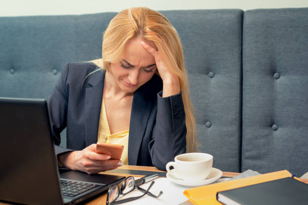 istock A beautiful woman is looking at smart phone with feeling sad at modern cafe. 1168420566