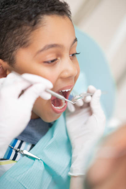 istock Handsome dark-haired boy opening mouth while visiting dentist 1168420954