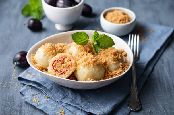 Freshly boiled plum dumplings topped with sweet toasted breadcrumbs stock photo