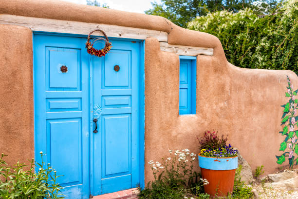 Ranchos de Taos, USA - June 19, 2019: Famous St Francic Plaza in New Mexico with turquoise adobe architecture color decorations on door