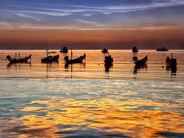 istock Traditional thai boats at sunset beach 1168423643