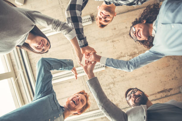 istock Startupers working at office together standing holding hands up bottom view let's do it happy 1168424296