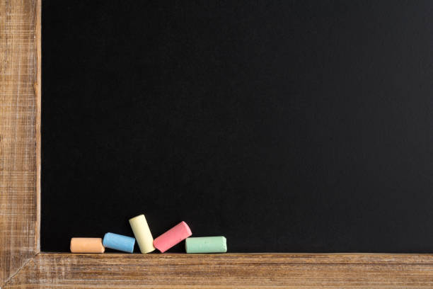 istock Small chalk pieces in different colors on a blackboard 1168424972